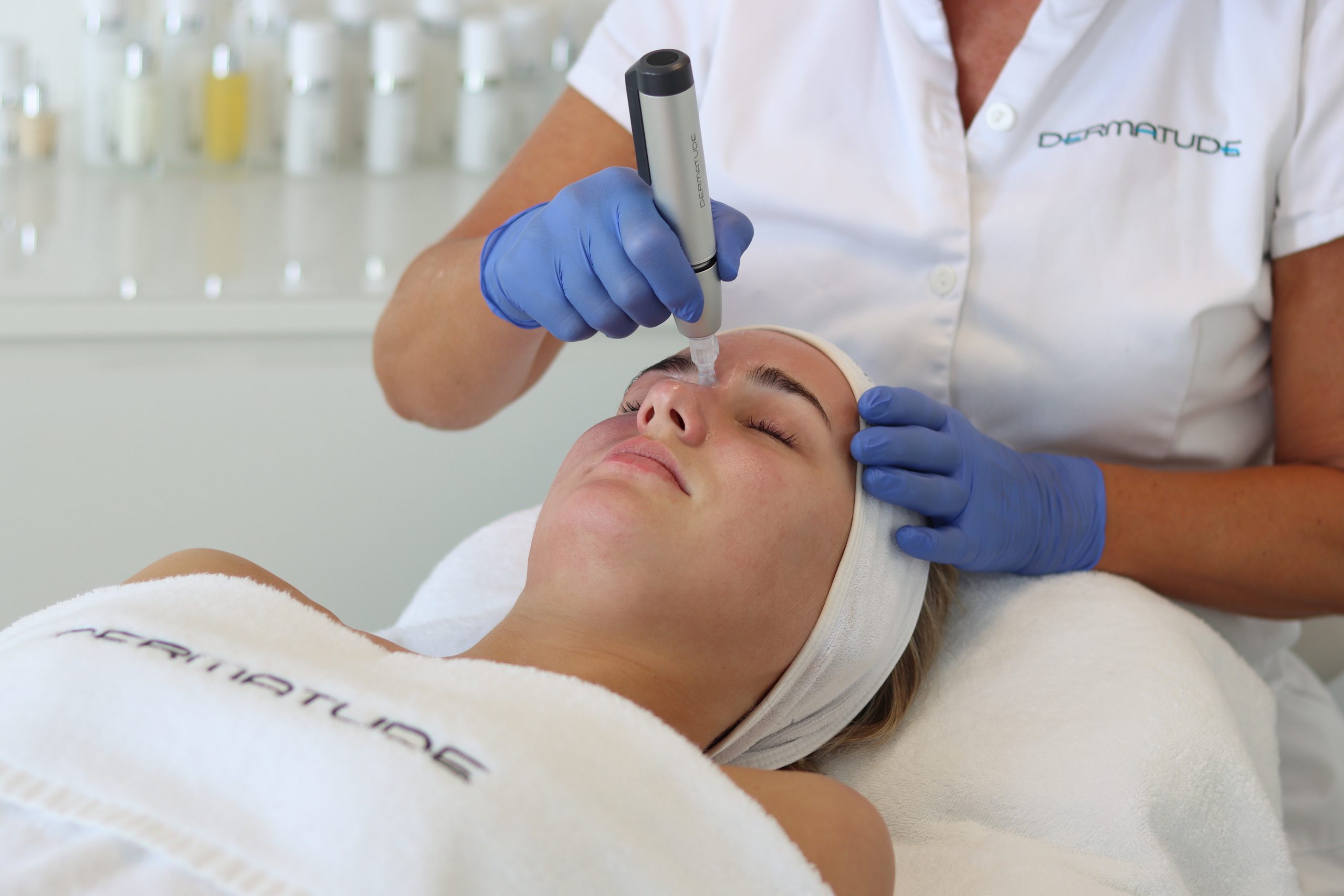 Ozadje zdravljenja z napravo Dermatude Meta Therapy z brezžično napravo in izdelki za nego kože